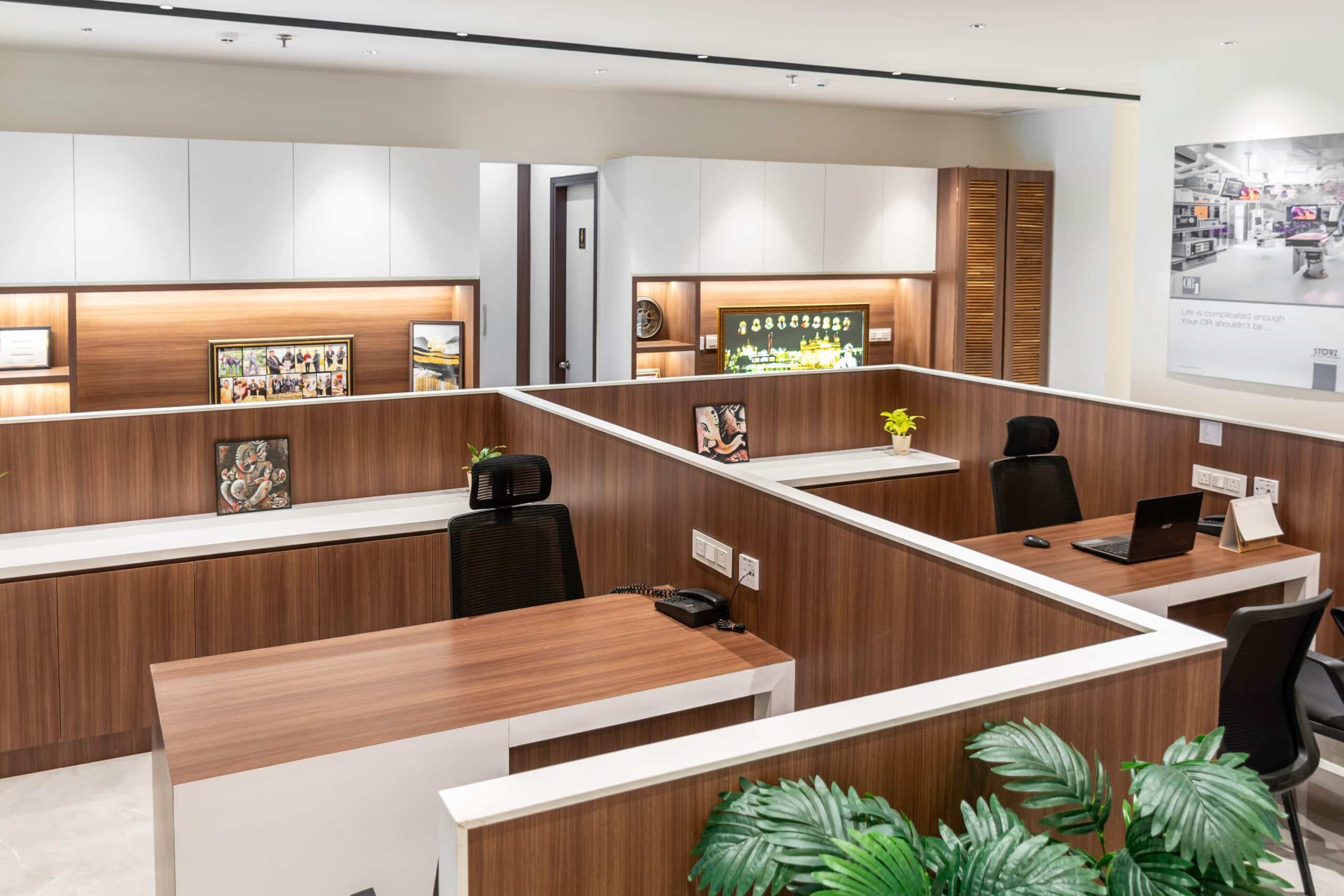 Modern open office workspace with wood-accented cubicles and ceiling lights